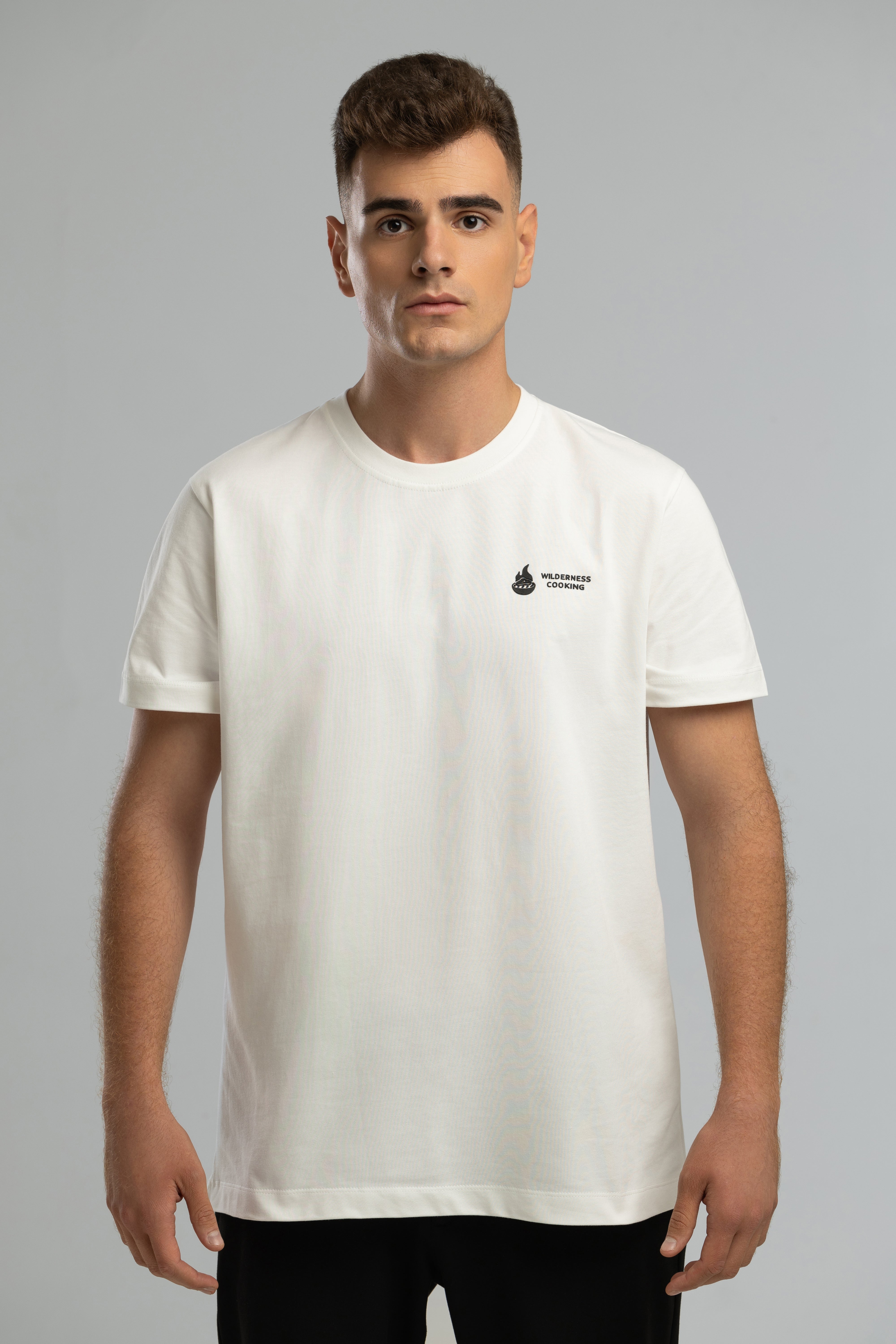 Ecrufarbenes T-Shirt im Stil von Mickey the Goat mit seitlichem Wilderness Cooking-Logo