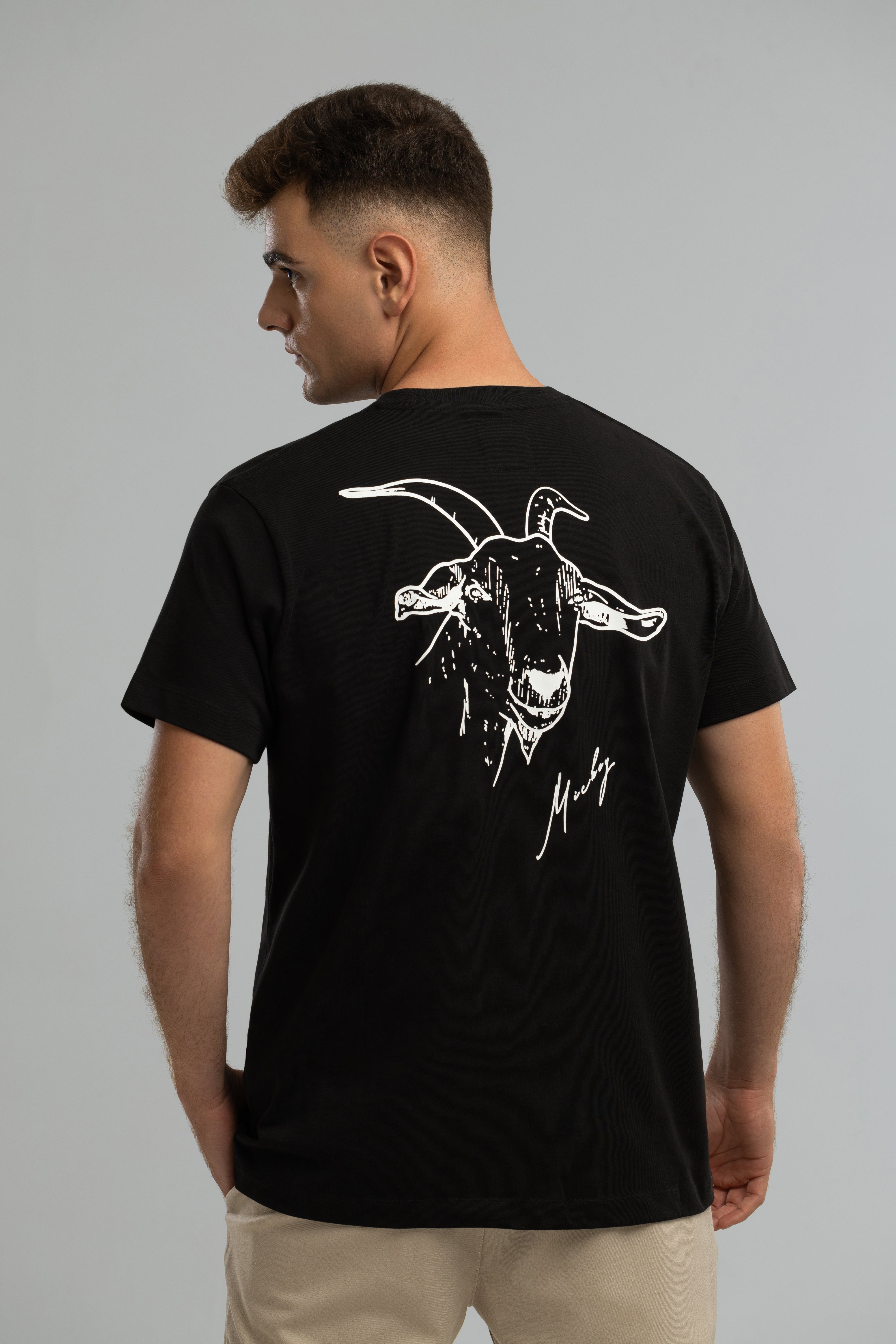 Schwarzes T-Shirt im Stil von Mickey the Goat mit seitlichem Wilderness Cooking-Logo