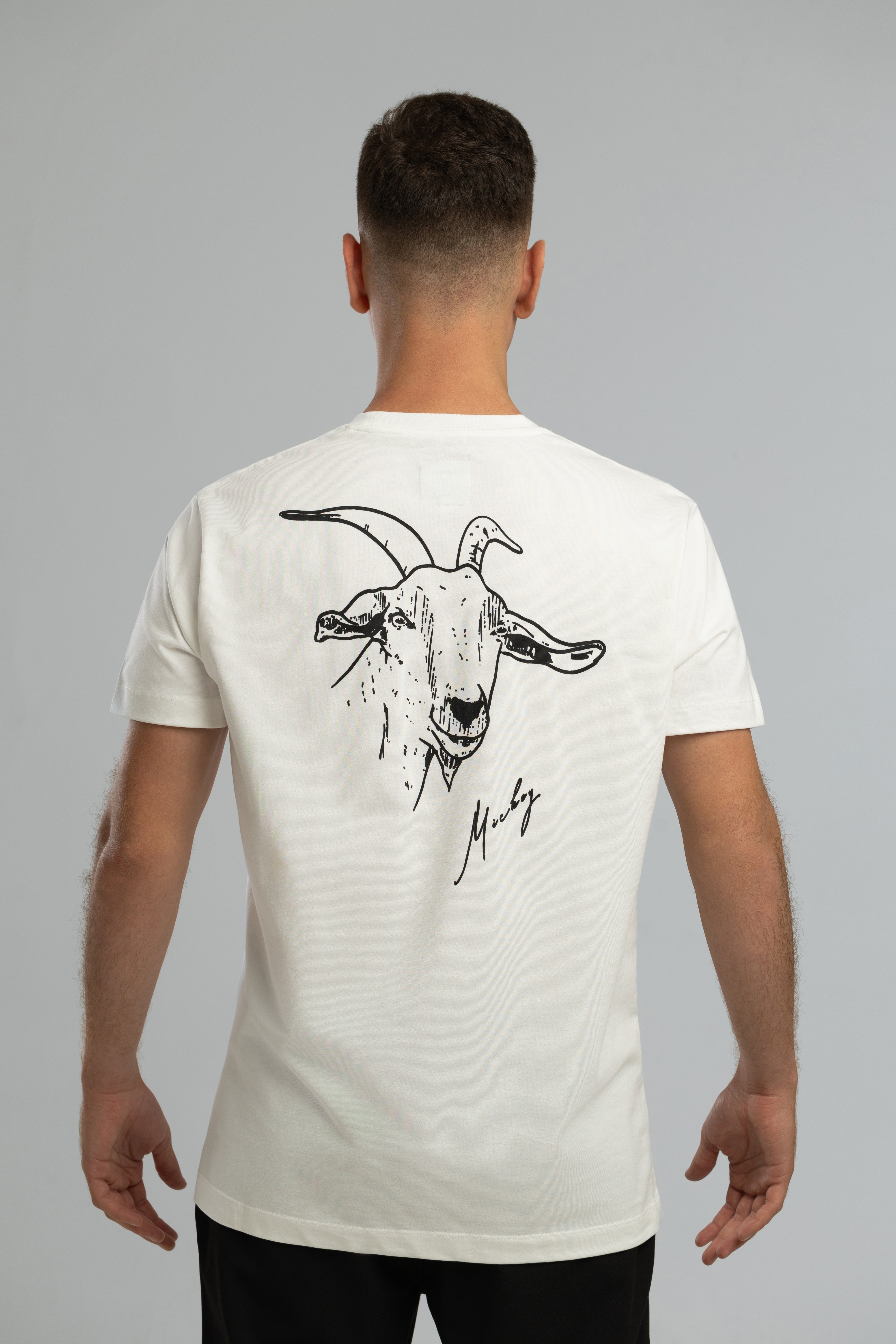 Ecrufarbenes T-Shirt im Stil von Mickey the Goat mit seitlichem Wilderness Cooking-Logo